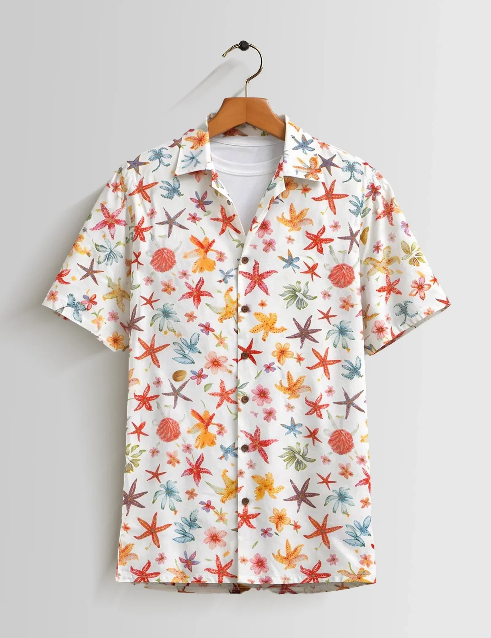 Colorful starfish pattern shirt on a hanger against a gray background