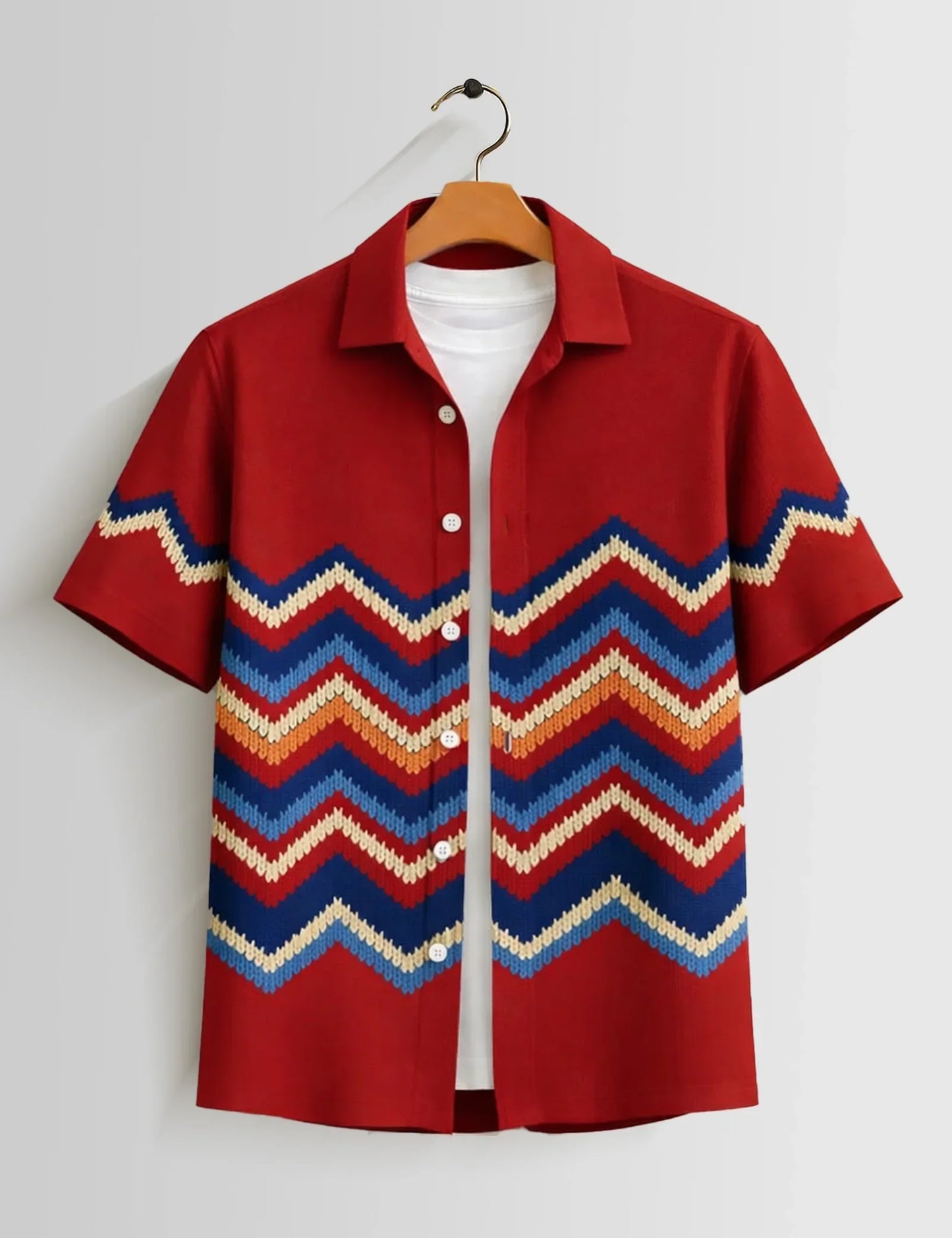 Red shirt with colorful zigzag pattern on a hanger against a white background